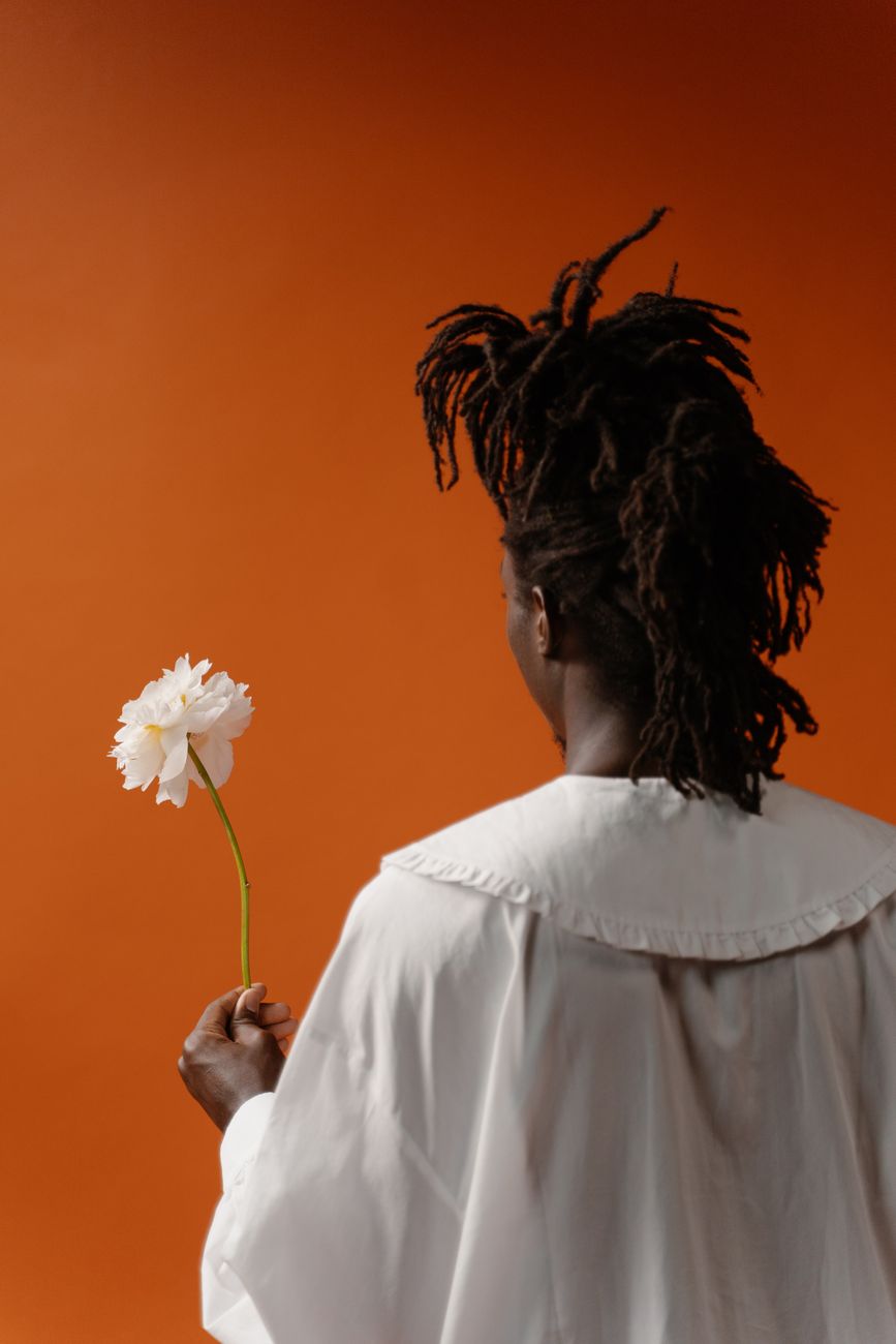 A person seen from behind against a deep orange wall
